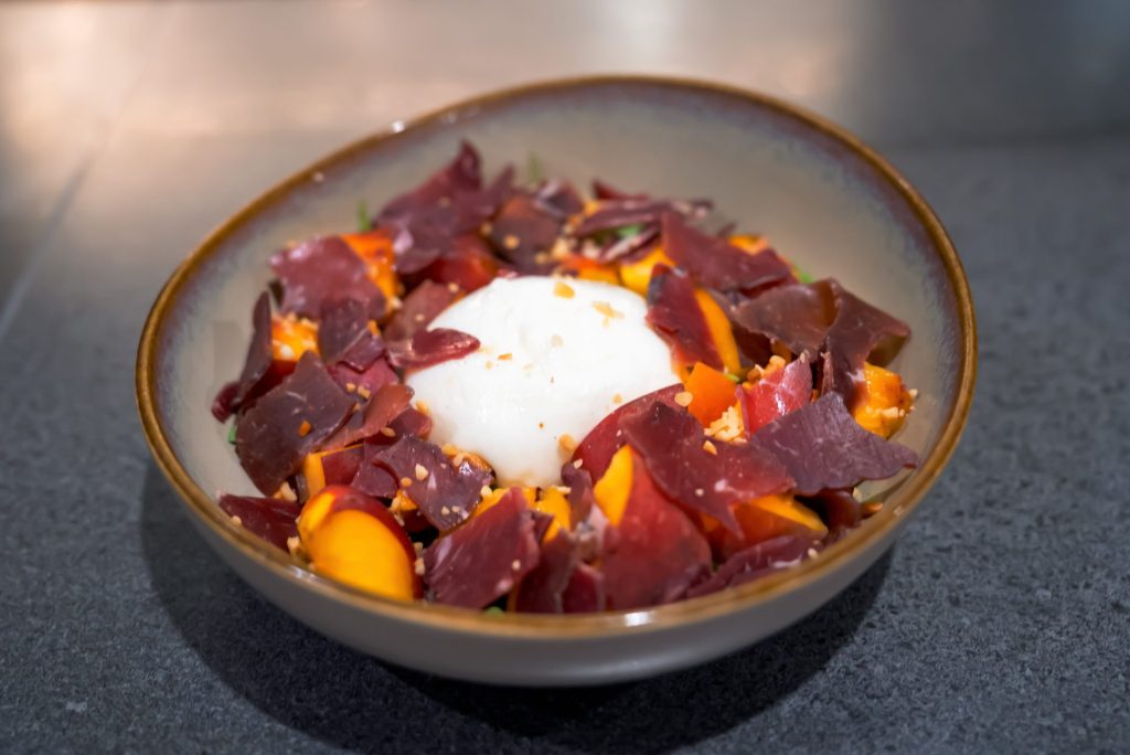 Burrata, bresaola et pêches, un plat de la carte du Mugs