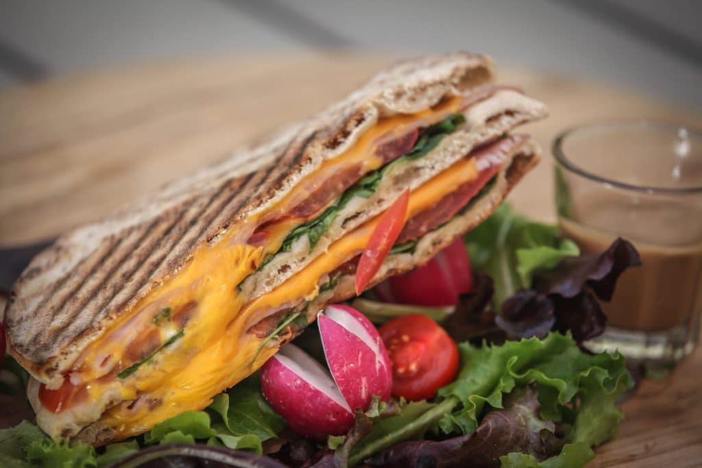 Club sandwich grillé au cheddar, servi avec une petite salade